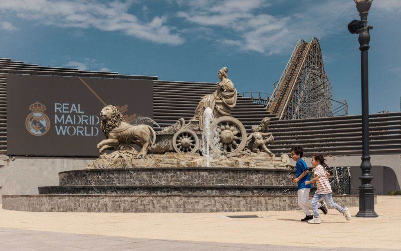 Two kids running in front of a water fountain at Real Madrid World, Dubai