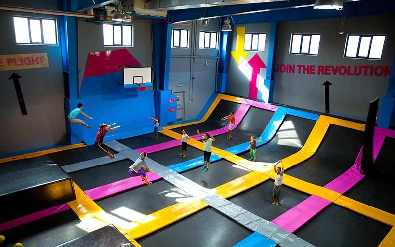 Kids playing at Bounce Dubai on black, blue, and pink trampolines